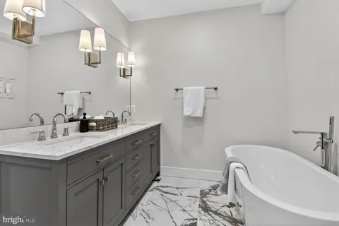 a bathroom with a granite countertop sink a toilet a mirror a vanity and shower