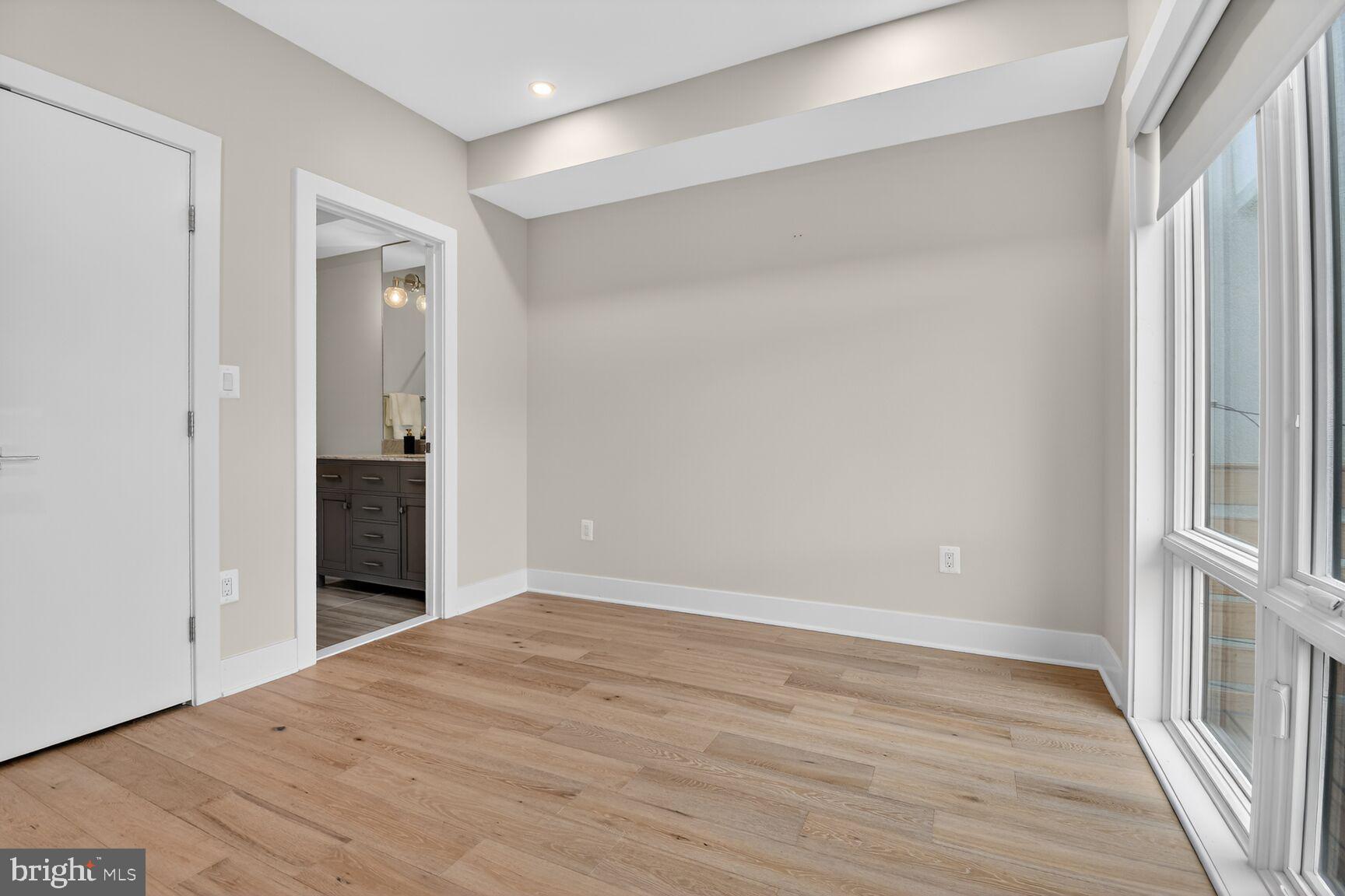 3532 1/2 13th Street Northwest, Unit 2 Washington, DC 20010 - Photo 26 of 38 a view of an empty room with wooden floor and a window