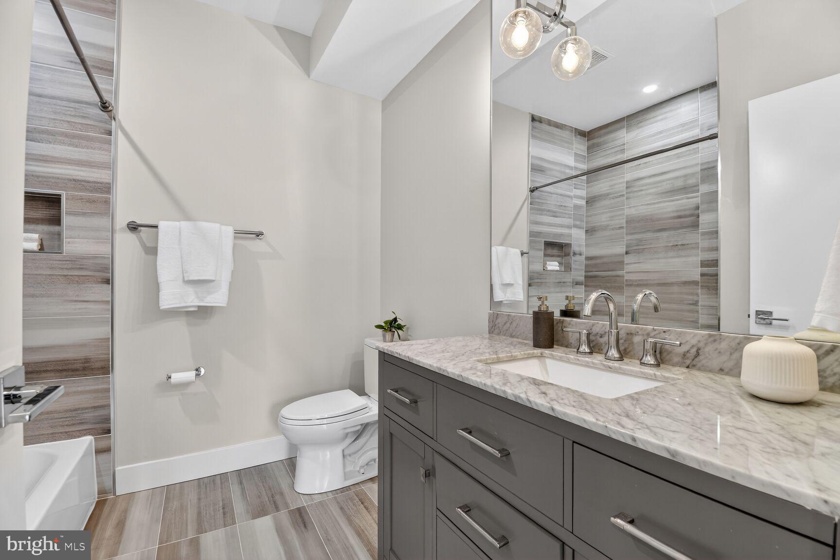 3532 1/2 13th Street Northwest, Unit 2 Washington, DC 20010 - Photo 27 of 38 a bathroom with a granite countertop sink a toilet and shower