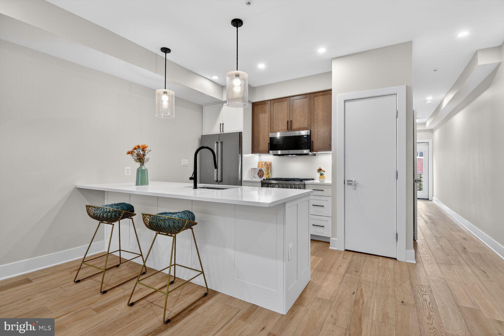 3532 1/2 13th Street Northwest, Unit 2 Washington, DC 20010 - Photo 8 of 38 a kitchen with kitchen island granite countertop a sink cabinets and wooden floor