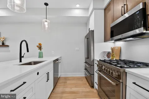 a kitchen with stainless steel appliances a sink a stove and a microwave