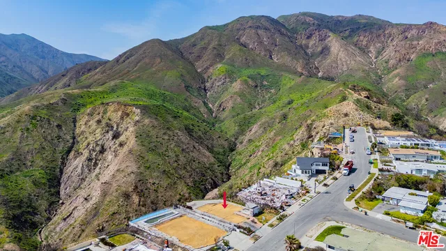 an aerial view of a residential houses and mountain view in back
