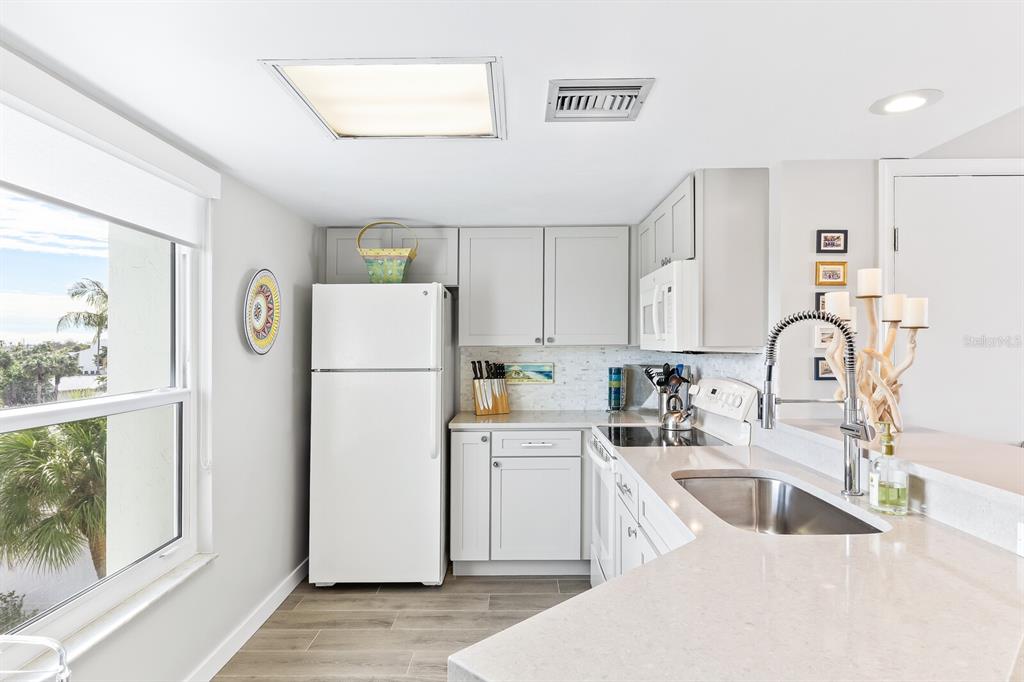 5000 Gasparilla Road, Unit DC307 Boca Grande, FL 33921 - Photo 6 of 33 a kitchen with a refrigerator a sink and cabinets