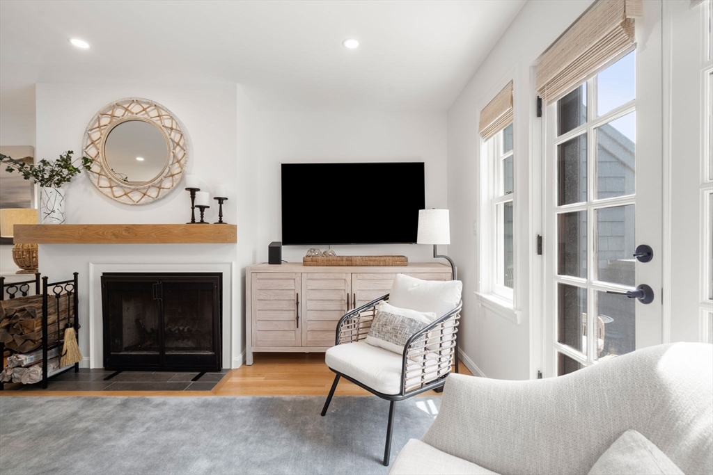 27 R West Street, Unit 13 Beverly, MA 01915 - Photo 12 of 34 a living room with furniture a flat screen tv and a fireplace