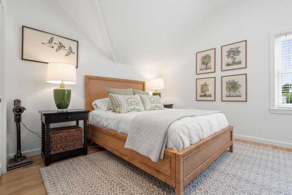 27 R West Street, Unit 13 Beverly, MA 01915 - Photo 15 of 34 a bed sitting in a bedroom next to a window with a lamp and a table