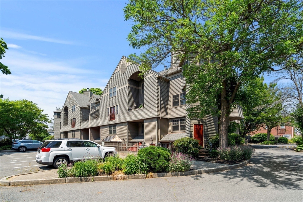 27 R West Street, Unit 13 Beverly, MA 01915 - Photo 29 of 34 a front view of a house with a yard and garage