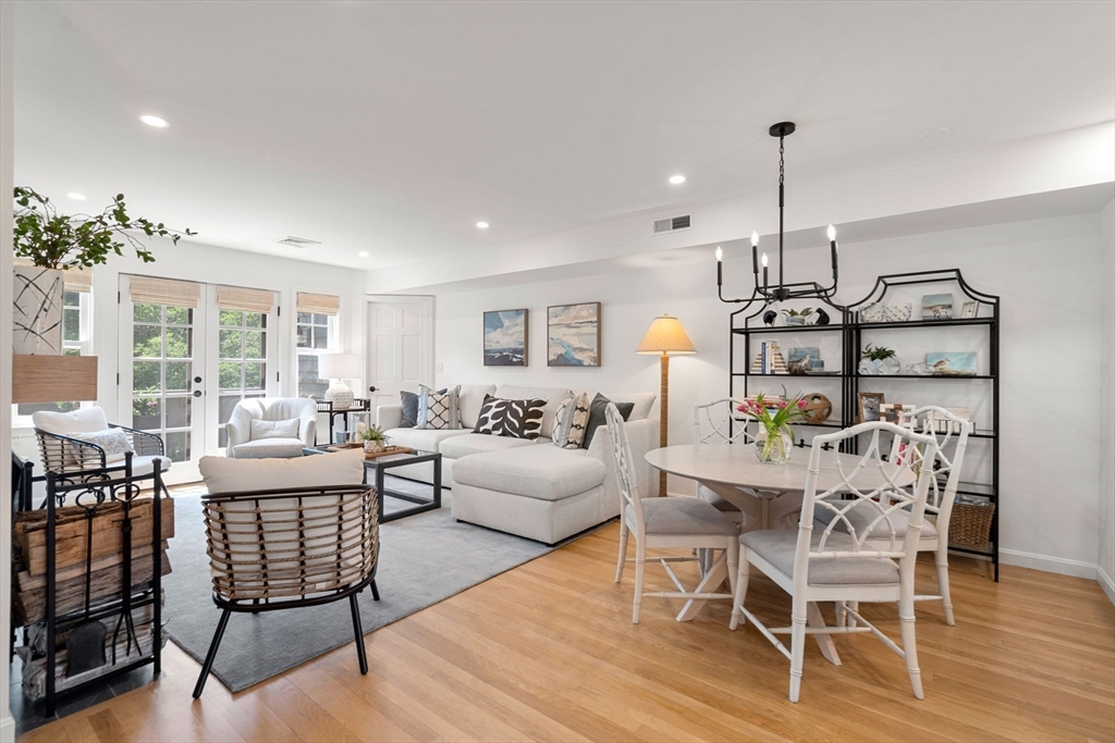 27 R West Street, Unit 13 Beverly, MA 01915 - Photo 34 of 34 a living room with furniture a chandelier and a dining table with wooden floor