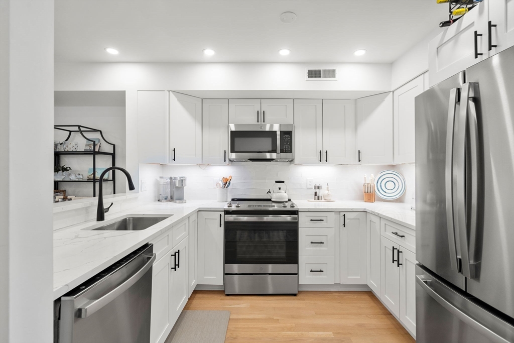 27 R West Street, Unit 13 Beverly, MA 01915 - Photo 4 of 34 a kitchen with granite countertop a sink stove and refrigerator