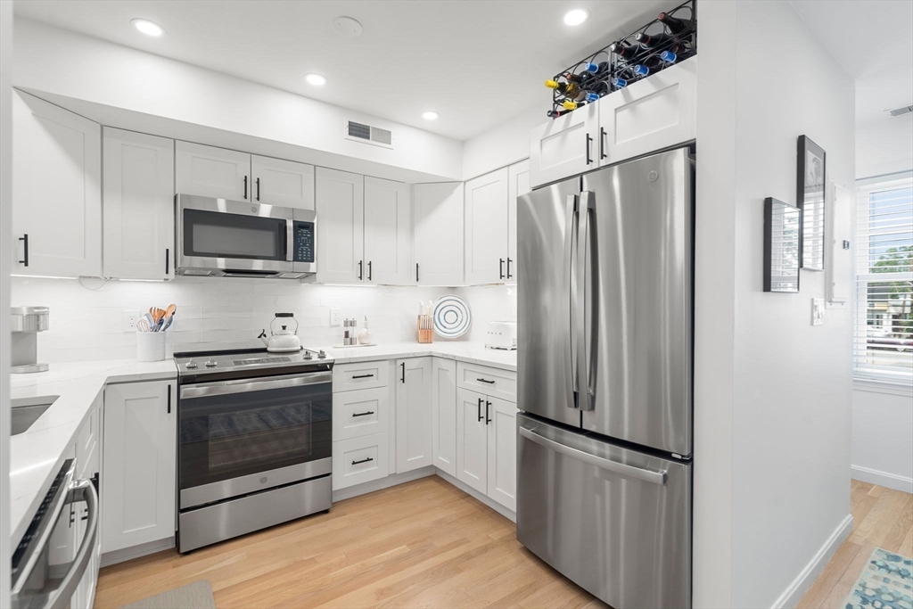 27 R West Street, Unit 13 Beverly, MA 01915 - Photo 9 of 34 a kitchen with stainless steel appliances a refrigerator sink and microwave