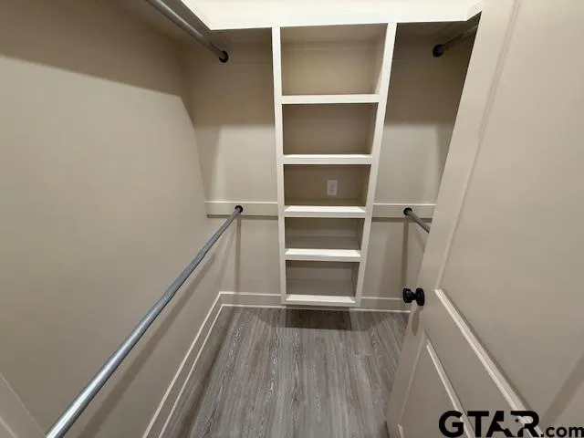 a view of walk in closet with empty racks
