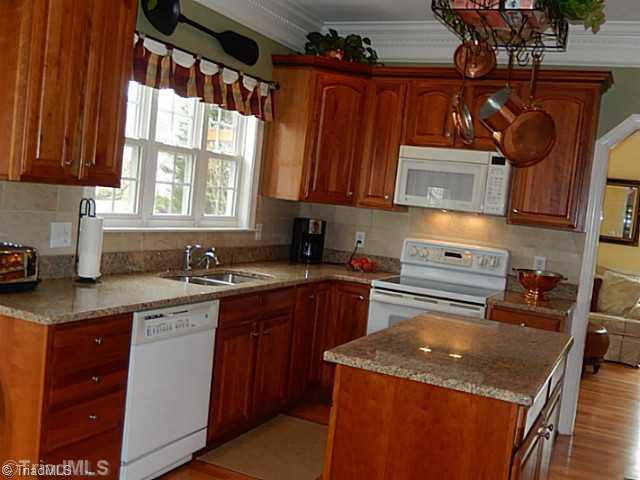 7802 Wilson Farm Road Summerfield, NC 27358 - Photo 8 of 16 Kitchen. Updated kitchen, new granite counter tops, tile back splash, lovely hardwood floors, island and pantry
