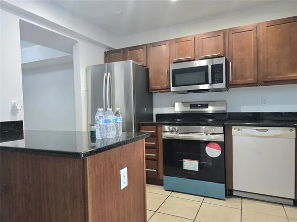 a kitchen with stainless steel appliances granite countertop a refrigerator stove and microwave