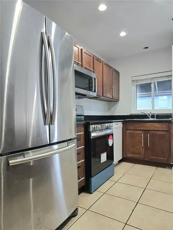 a kitchen with stainless steel appliances granite countertop a refrigerator and a sink