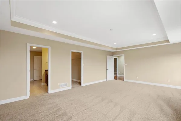 a view of an empty room with closet and a window