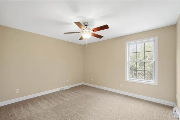 an empty room with a window and a fan