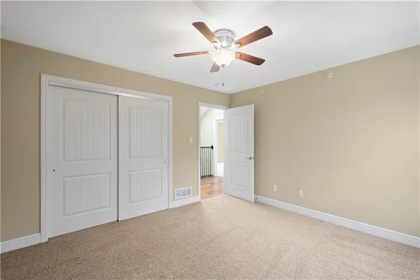 an empty room with closet and fan