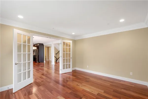 a view of an empty room with wooden floor and entryway
