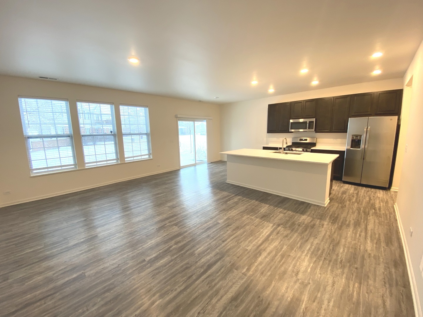 1208 Draper Road McHenry, IL 60050 - Photo 3 of 22 a view of a big room with wooden floor and windows