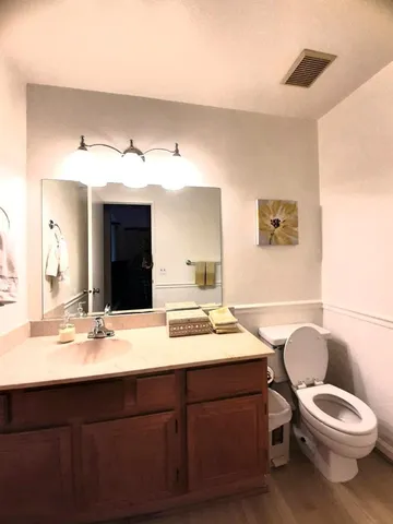 a bathroom with a toilet a sink and mirror