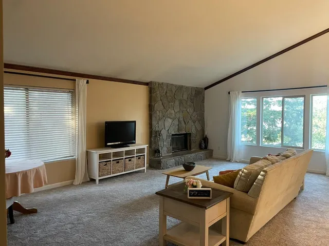 a living room with furniture a flat screen tv and a fireplace