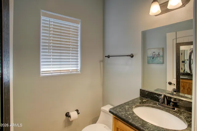 wooden floor in an empty room with a fireplace and a window