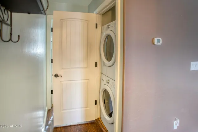 a view of an empty room with wooden floor a fireplace and a window