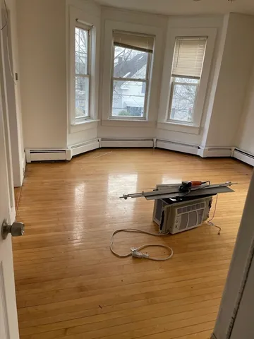 a room with stainless steel appliances wooden floor and window