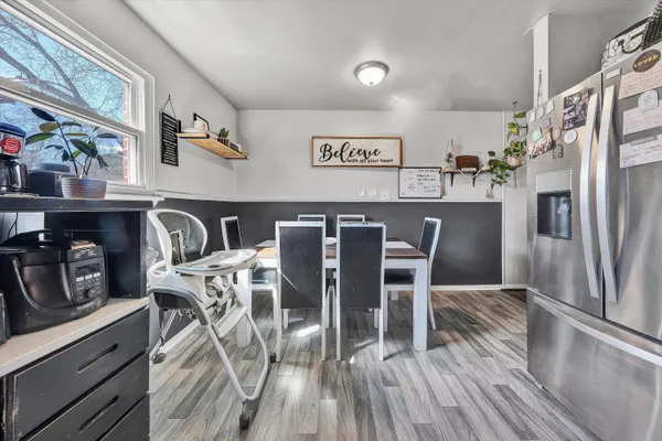 a kitchen with stainless steel appliances a table chairs and a refrigerator