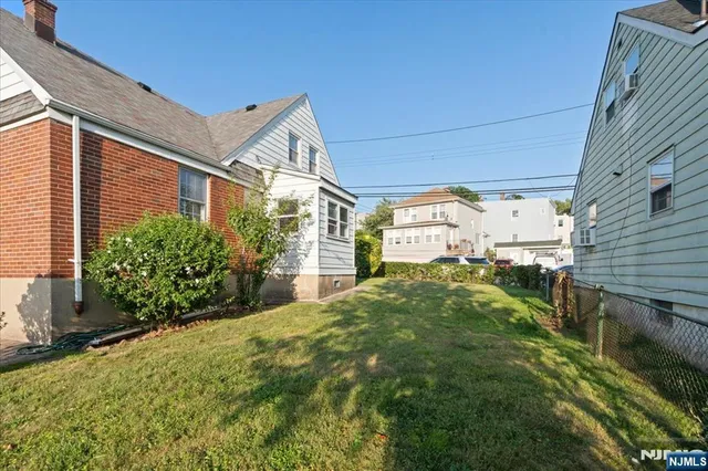 a view of a big house with a big yard and large trees