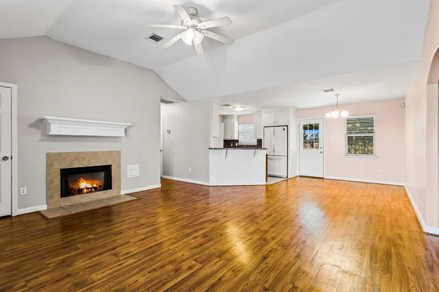 a view of empty room with wooden floor and fireplace