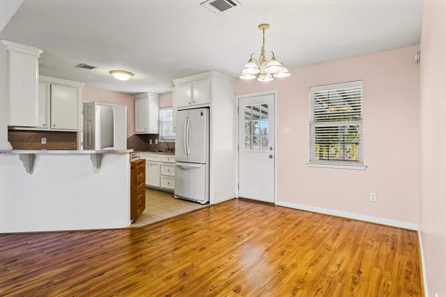 a kitchen with stainless steel appliances granite countertop a refrigerator a oven a sink with dishwasher and wooden cabinets