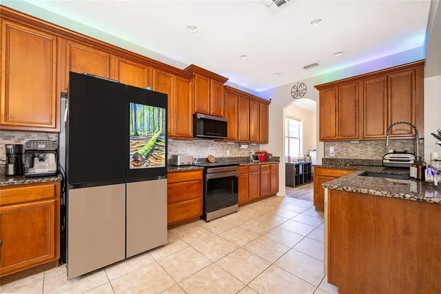 a kitchen with stainless steel appliances granite countertop a stove a sink a microwave and a refrigerator