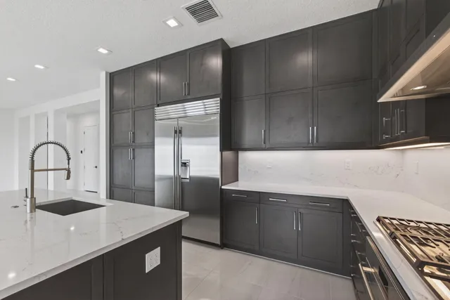 a large room with kitchen island a sink stainless steel appliances and cabinets