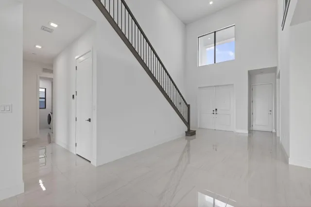 a view of staircase with railing and white walls