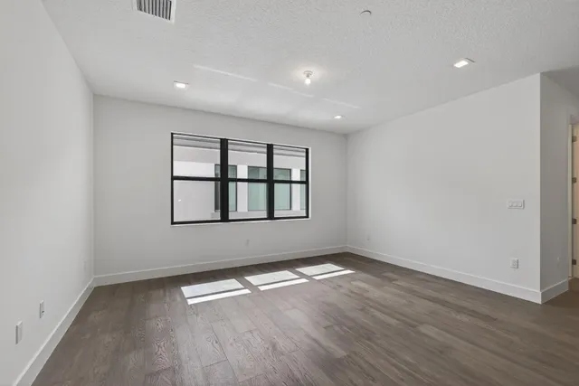 an aerial view of a swimming pool with a yard and plants