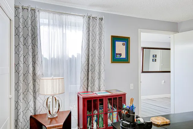 a view of a workspace with furniture and a window
