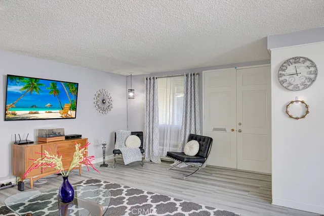 a living room with furniture a flat screen tv and a window