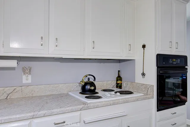 a kitchen with stainless steel appliances granite countertop white cabinets and a stove