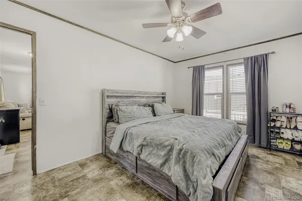 a bedroom with a bed chandelier and a window