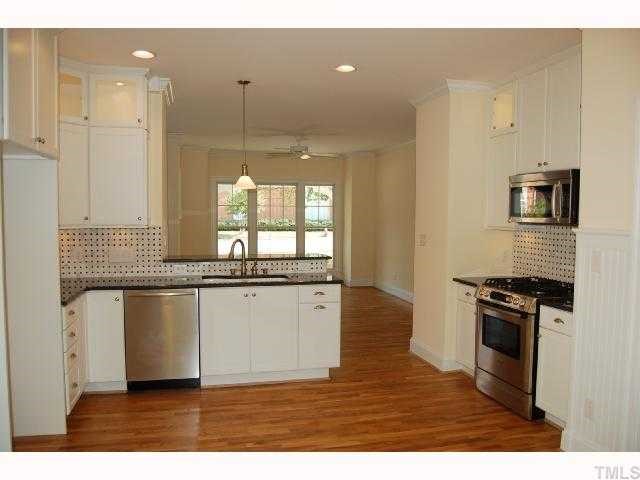 2113 Noble Road Raleigh, NC 27608 - Photo 3 of 11 a kitchen with granite countertop a stove a sink and a wooden floors
