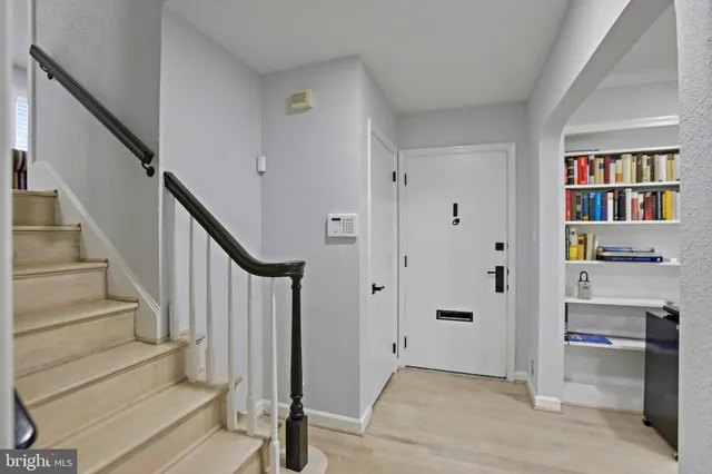 a view of a hallway with wooden floor and entryway