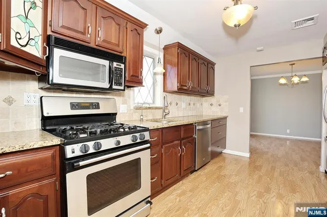 a kitchen with stainless steel appliances granite countertop a stove a microwave and a sink
