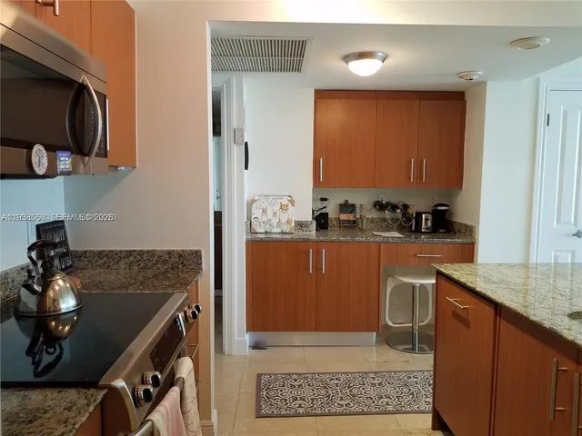 a kitchen with stainless steel appliances granite countertop a sink stove and cabinets