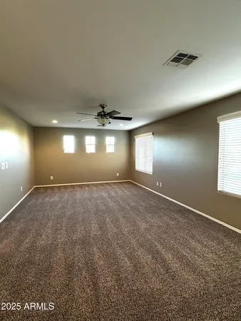 en empty room with windows and ceiling fan