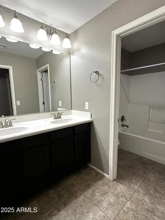 a bathroom with a double vanity sink and a mirror