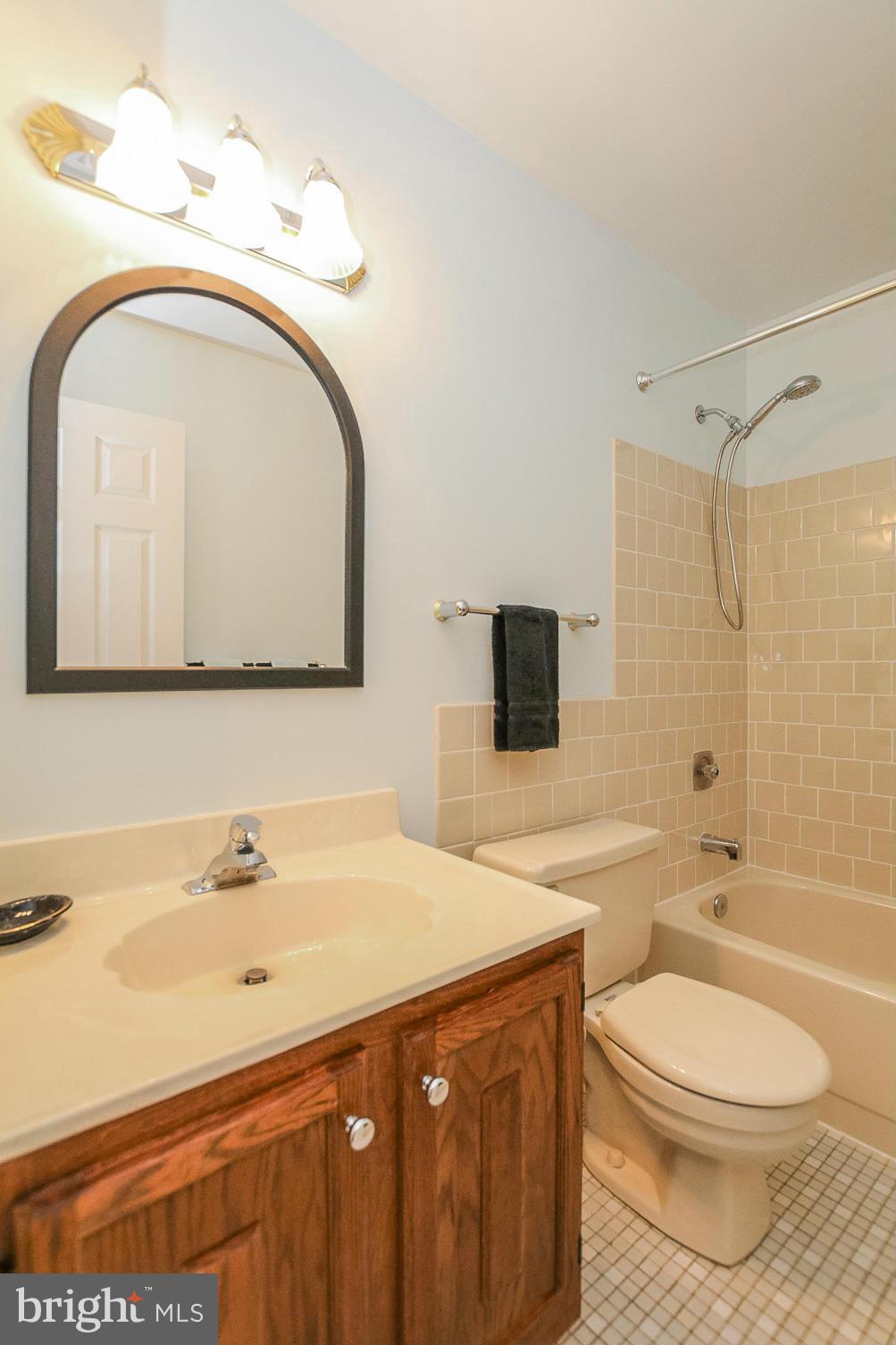 9338 Oak White Road Baltimore, MD 21236 - Photo 16 of 27 a bathroom with a toilet a sink and mirror