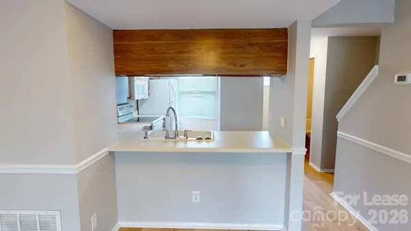 a view of a hallway with wooden floor and furniture