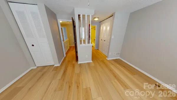 an empty room with a window and a ceiling fan