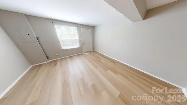 a view of a room with wooden floor and a window