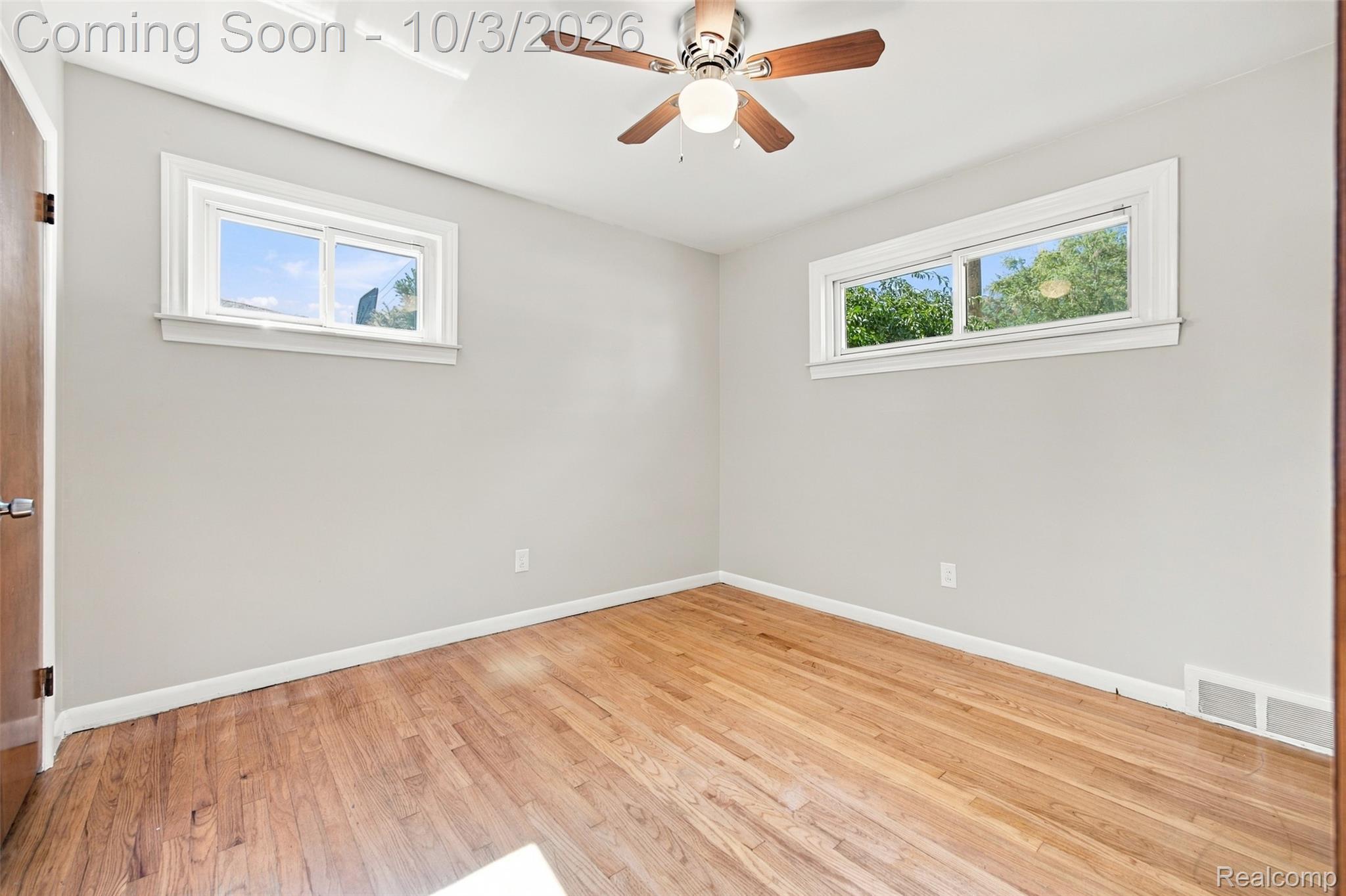 556 Henry Ruff Road Garden City, MI 48135 - Photo 14 of 49 Hardwood flooring, painted walls, two windows with white trim, and a ceiling fan with light fixture